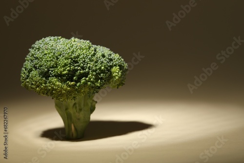 Fresh raw broccoli on beige background, closeup. Space for text