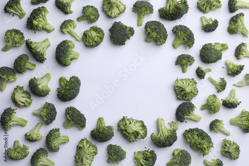Frame made of many fresh green broccoli pieces on white background, flat lay. Space for text