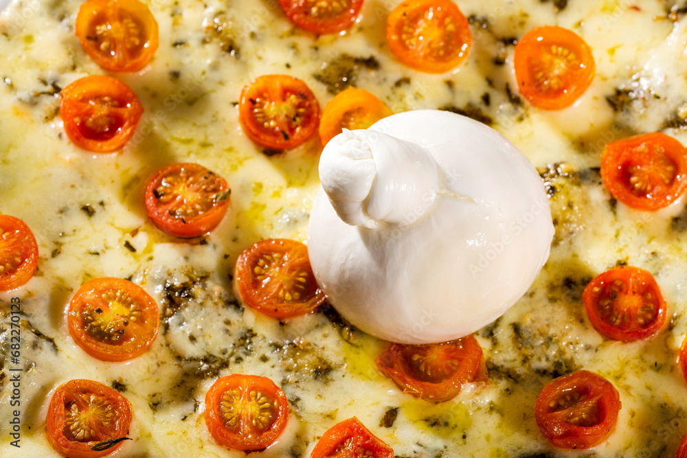 Artisanal fresh cheese burrata on pizza with tomatoes