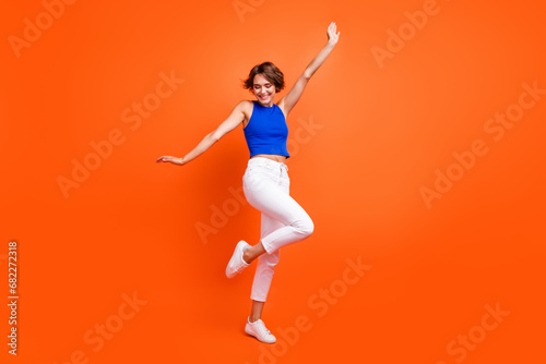 Full size photo of gorgeous lovely girl have good mood dancing rejoice isolated on vivid orange color background