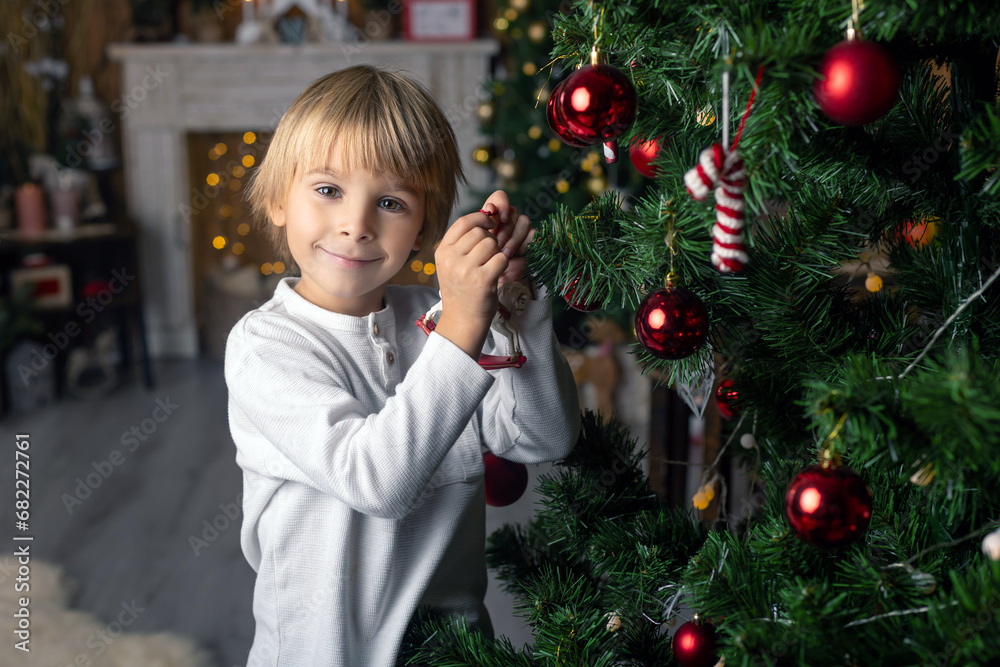 Beautiful blond child, young school boy, writing homework for school in a decorated home, drinking milk and eating cookies Beautiful blond child, young school boy, writing homework for school in a decorated home, drinking milk and eating cookies