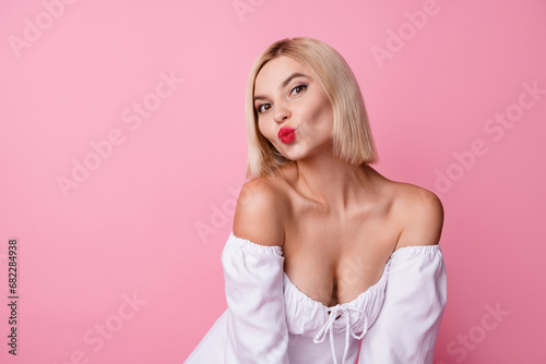 Photo of lovely pretty girl dressed white trendy clothes sending you kiss empty space isolated on pink color background