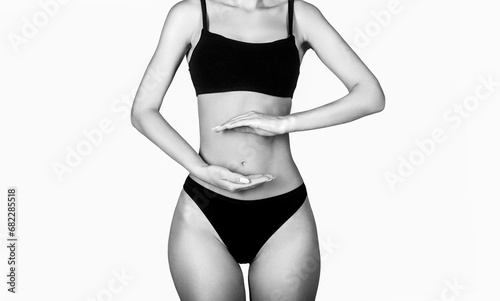 Health care concept, closeup. Young multi-ethnic woman's stomach. Closeup woman hands made protect shape stomach. Black and white