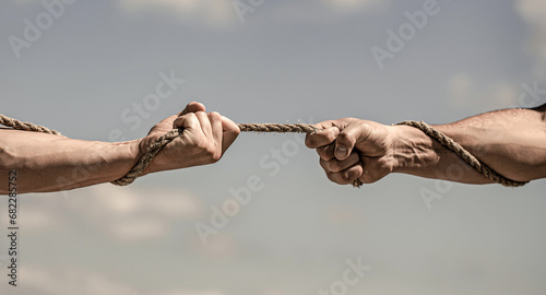 Conflict tug of war. Hand holding a rope, climbing rope, strength and determination. Rescue, help, helping gesture or hands
