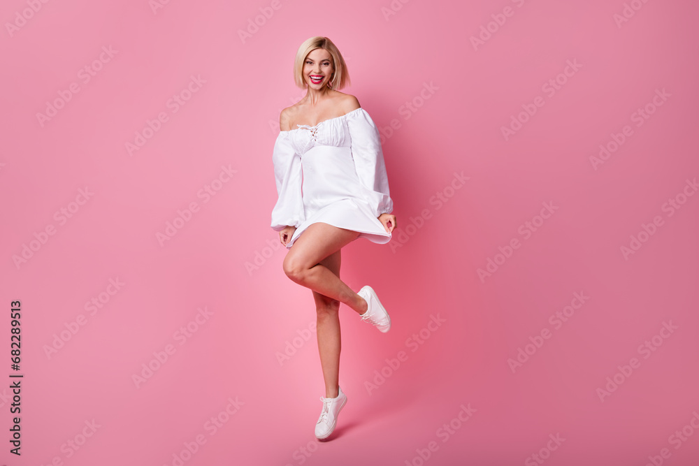 Full size photo of pretty nice cute woman with bob hairstyle dressed white clothes jumping on one hand isolated on pink color background Full size photo of pretty nice cute woman with bob hairstyle dressed white clothes jumping on one hand isolated on pink color background
