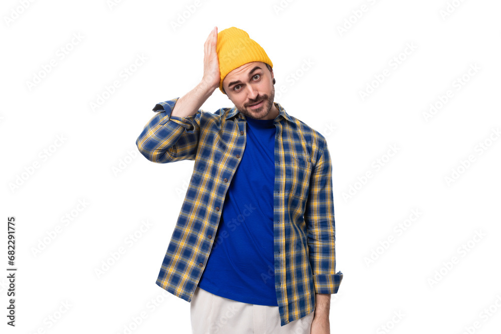 handsome smart young male hipster in cap and shirt thinking over white background with copy space