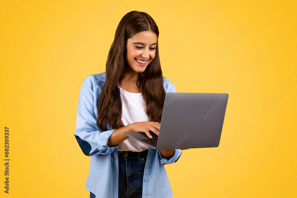 Happy pretty european teenager student lady typing on computer Happy pretty european teenager student lady typing on computer