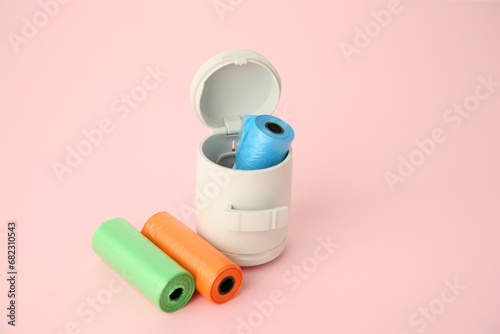 Dog waste bags and dispenser on pink background