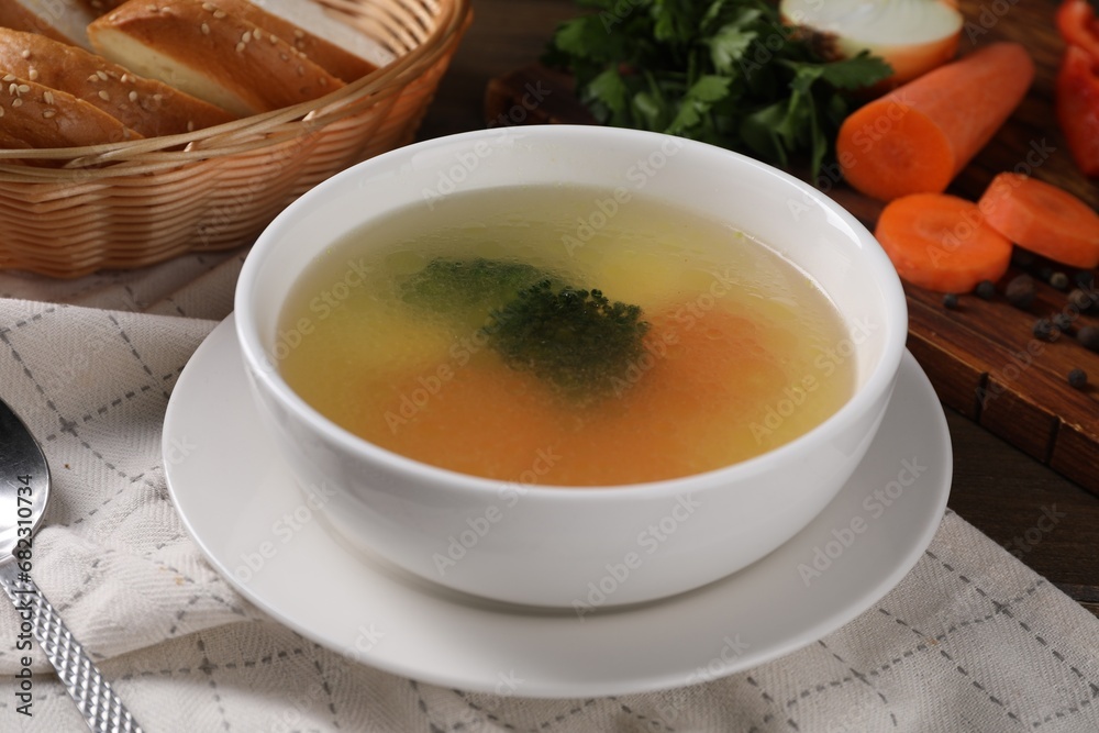 Tasty soup with vegetables in bowl served on wooden table, closeup Tasty soup with vegetables in bowl served on wooden table, closeup