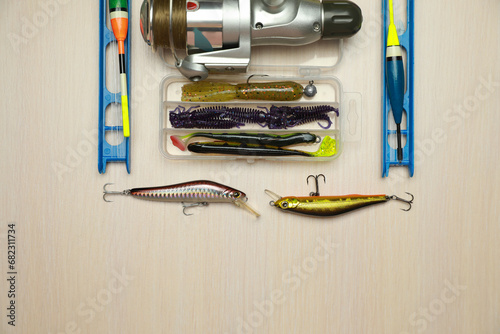Different fishing equipment on light wooden table, flat lay. Space for text