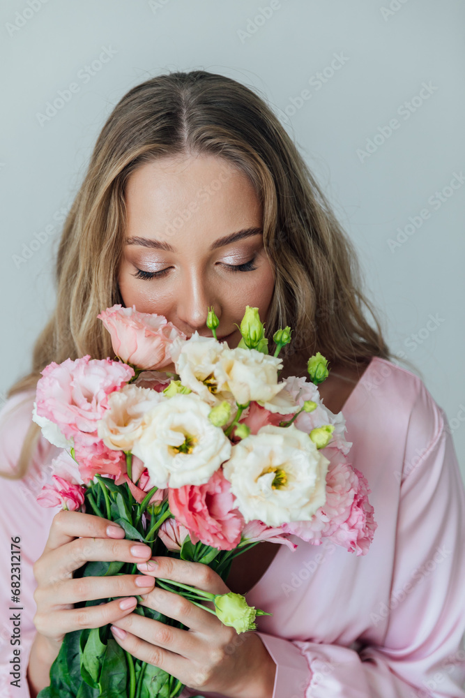 Beautiful woman in pink dress with flowers in the room for a holiday Beautiful woman in pink dress with flowers in the room for a holiday