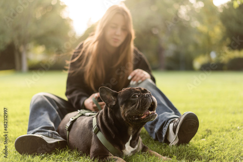 Girl hugs her French bulldog dog 