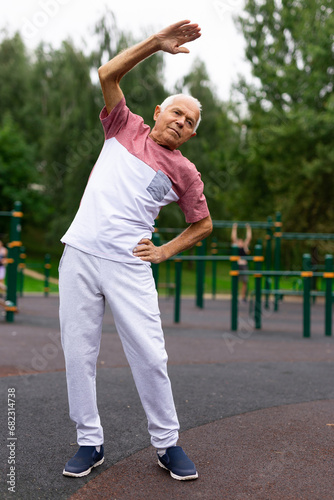 Elderly man doing fitness exercises outdoors
