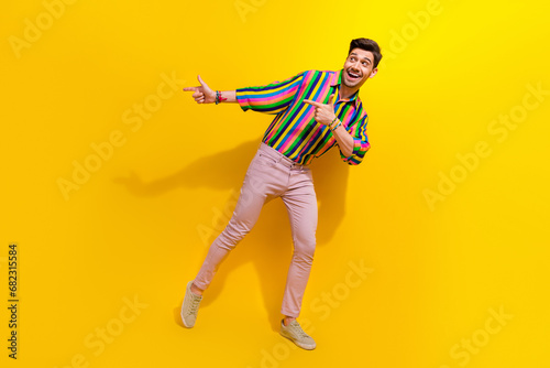 Full body photo of man in vintage outfit direct fingers empty space enjoy spend money in old school bar isolated on yellow color background