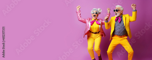 Cool retired hipsters, seniors party, carnival. Portrait of cheerful elderly gray-haired bearded grandparent wearing funny sunglasses and bright extravagant clothes on plain pink background photo