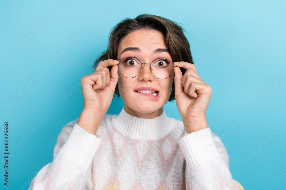 Photo portrait of attractive young woman bite lips excited touch eyewear wear trendy white clothes isolated on blue color background Photo portrait of attractive young woman bite lips excited touch eyewear wear trendy white clothes isolated on blue color background
