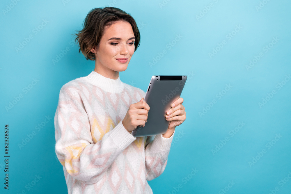 Photo portrait of attractive young woman hold tablet reading ebook dressed stylish white clothes isolated on blue color background Photo portrait of attractive young woman hold tablet reading ebook dressed stylish white clothes isolated on blue color background