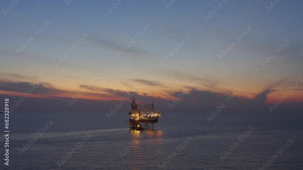 Aerial view of offshore jack up drilling rig during early night time - oil and gas industry
