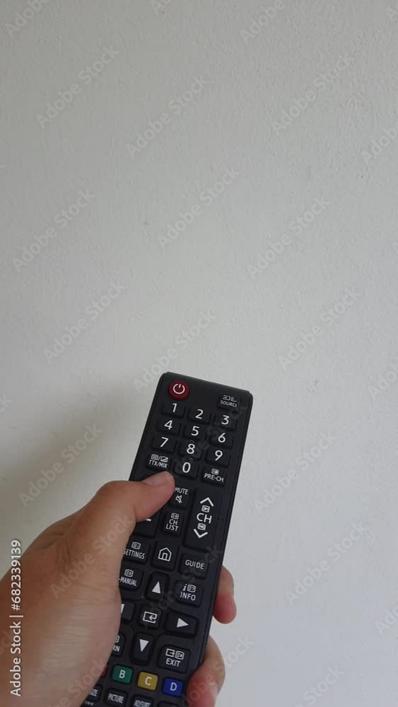 A hand is operating a television remote control. Change channels up and down, turn the volume up and down, and turn the power on and off. A hand is operating a television remote control. Change channels up and down, turn the volume up and down, and turn the power on and off.