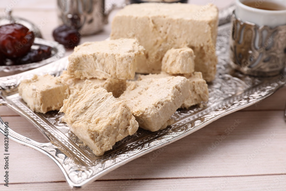 Pieces of tasty halva on light wooden table, closeup Pieces of tasty halva on light wooden table, closeup