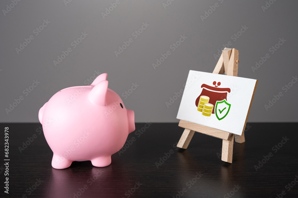 Fototapeta The piggy bank looks at guaranteeing the safety of savings
