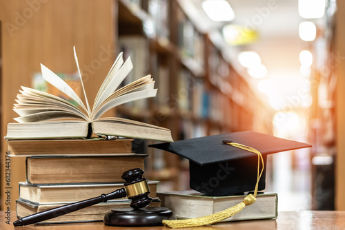 Law education, legal educational study, school for lawyer, legistration, litigation, judicial knowledge learning concept with court judge gavel and textbook with mortarboard on books in library photo