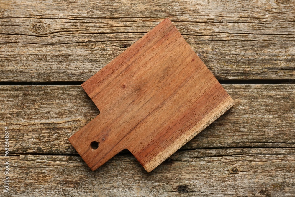 One new cutting board on old wooden table, top view One new cutting board on old wooden table, top view
