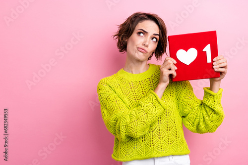 Photo blogging lady wearing yellow knitted jumper hold red heart click button look empty space thoughtful isolated on pink color background photo