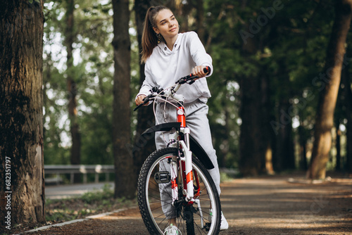 Young sporty woman riding bicycle in the park