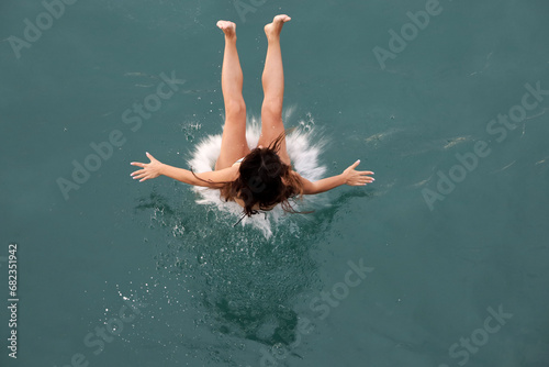 Girl jumping in sea, top view. Beach vacation, swimming and diving