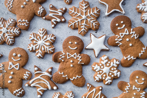 Homemade gingerbread Christmas cookies in icing sugar. Delicious gingerbread cookies on the background of a bokeh of Christmas tree lights. Freshly baked Christmas gingerbread cookies.