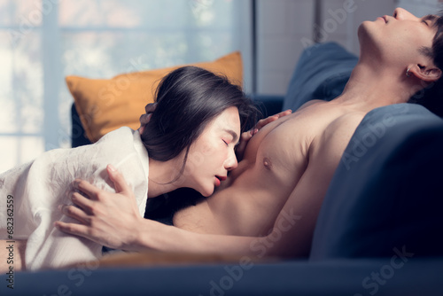 In the living room at home, a sexy woman in lingerie lies on the sofa in love with her spouse. photo