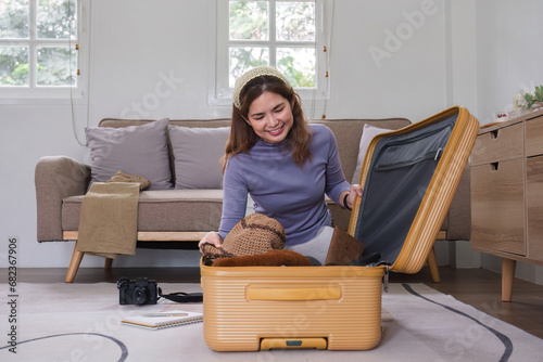 Quadro em tela Attractive asian young woman packing a travel bag before going on holiday