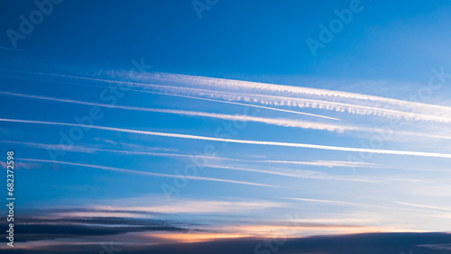 Cloudscape with trail of jet plane. Vapor trail from jets in a blue sky