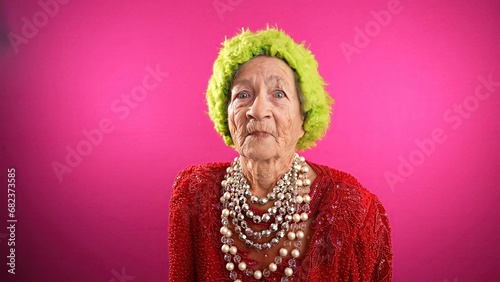 Fotografia Displeased unhappy fisheye portrait caricature of funny elderly woman saying NO with green hat isolated on pink background
