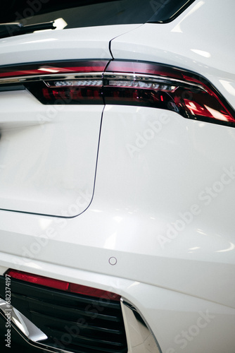 Closeup of car tail light on a white car.