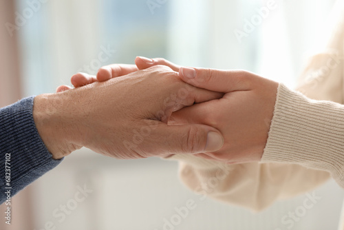 Trust and deal. Man with woman joining hands on blurred background, closeup