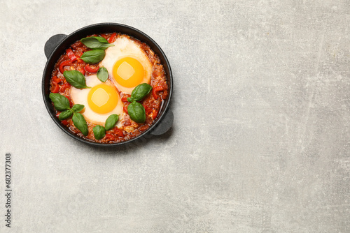 Delicious Shakshuka on light grey table, top view. Space for text