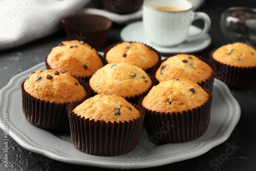 Delicious freshly baked muffins with chocolate chips on table, closeup