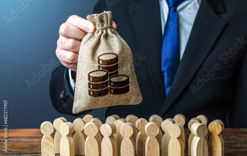 Businessman holds out a money bag to the crowd. Providing money, paying salaries and grants. Official. Staff maintenance. Compensation payments. Financial support. Tax collection. photo