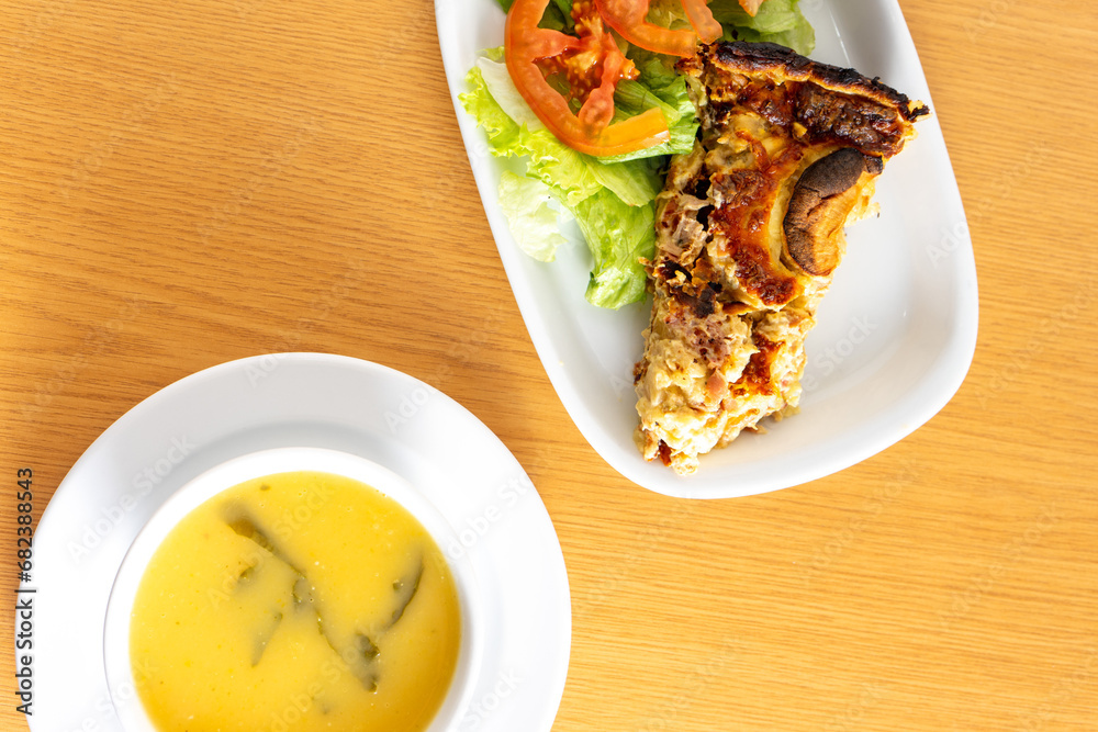 Mouthwatering mushroom quiche paired with fresh salad and a comforting turnip greens soup, served at a cozy snack bar.