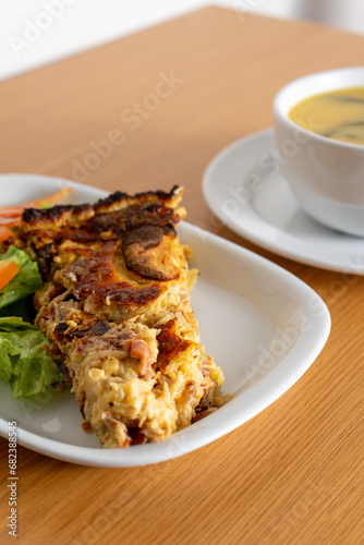 Mouthwatering mushroom quiche paired with fresh salad and a comforting turnip greens soup, served at a cozy snack bar.