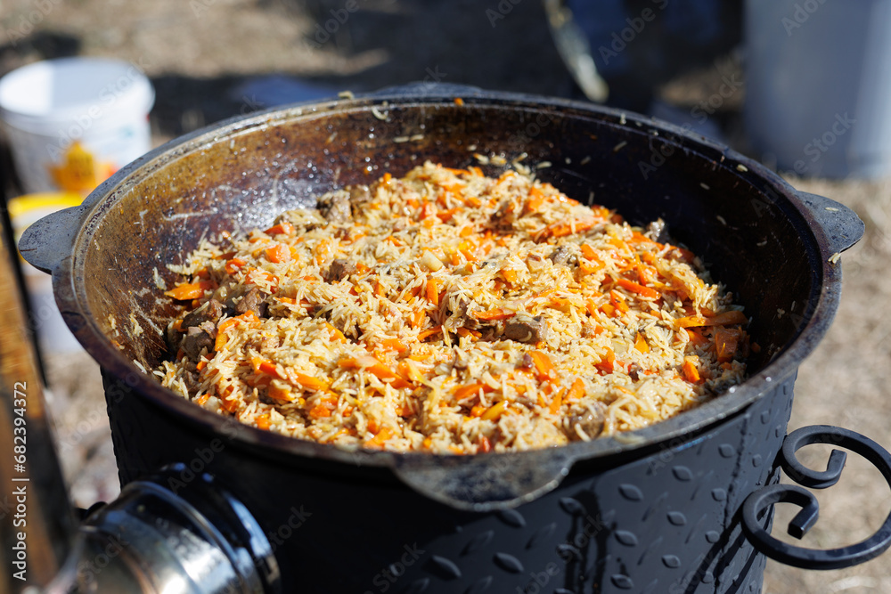 Uzbek national dish pilaf rice in a cast iron cauldron Uzbek national dish pilaf rice in a cast iron cauldron