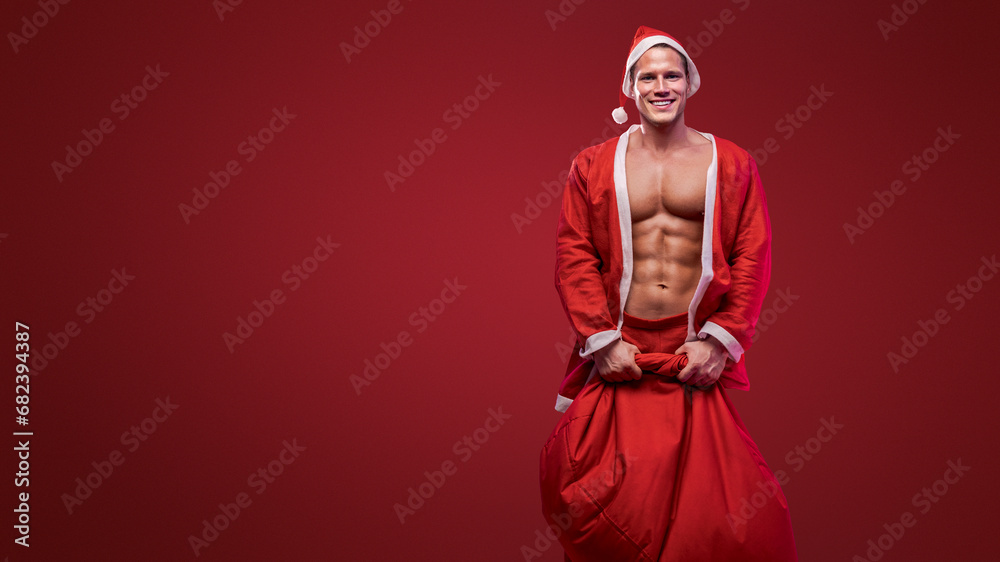 Cheerful Santa holding a gift sack, combining holiday joy with a fit physique Cheerful Santa holding a gift sack, combining holiday joy with a fit physique