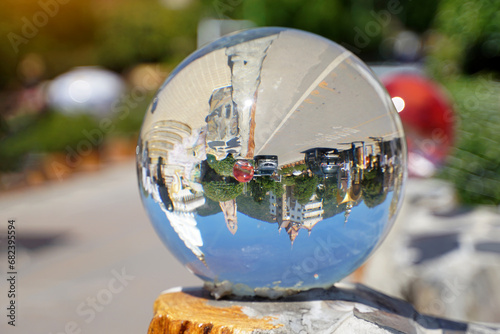 Upside-down realistic pictures of people Buildings and cars travel on the road in clear, spherical crystal balls decorated on the walls, which act like convex lenses. Soft and selective focus. © Aoy_Charin