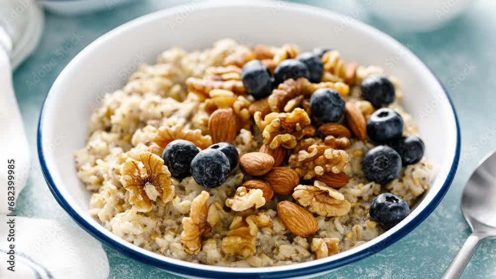 Oatmeal porridge with blueberry, almonds, walnuts, flax seeds, sesame and chia. Healthy vegetarian food for breakfast, stock video, footage 4k Oatmeal porridge with blueberry, almonds, walnuts, flax seeds, sesame and chia. Healthy vegetarian food for breakfast, stock video, footage 4k