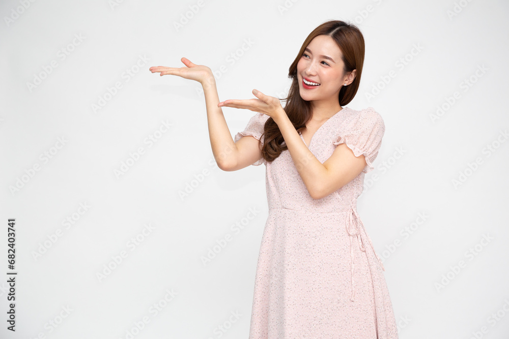Happy Asian woman presenting or showing open hand palm with copy space for product isolated over white background Happy Asian woman presenting or showing open hand palm with copy space for product isolated over white background