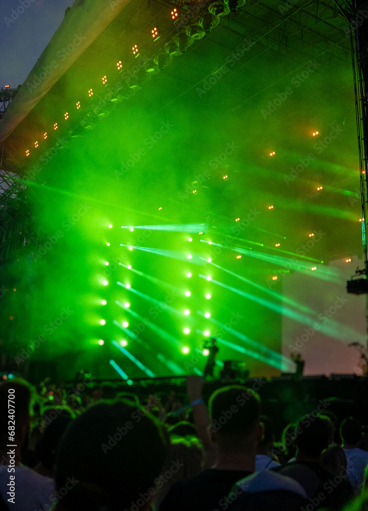 Large concert. Smoke effects and green neon lights show on stage