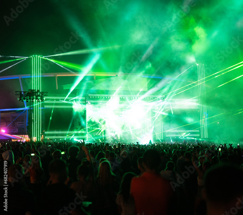 Neon stage lights at a concert. Audience partying and dancing