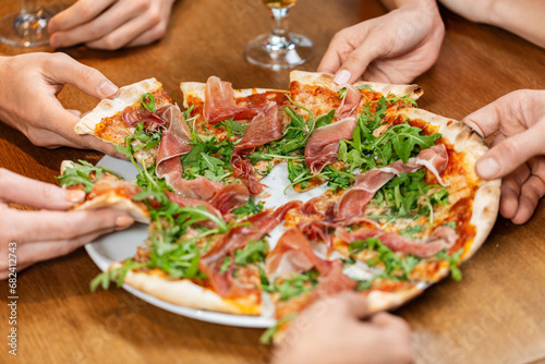 leisure, food and drinks, people and holidays concept - close up of friends eating pizza at restaurant or pub